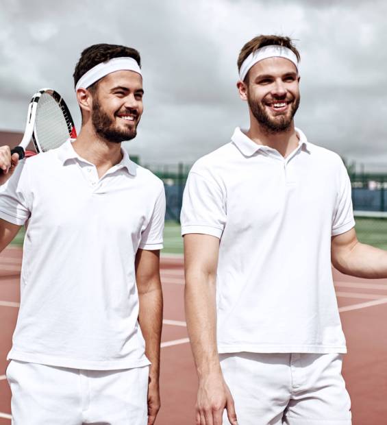 Business, partnership and sport. Business partners practicing sport together. Young men walking and looking to tennis court before a tennis set